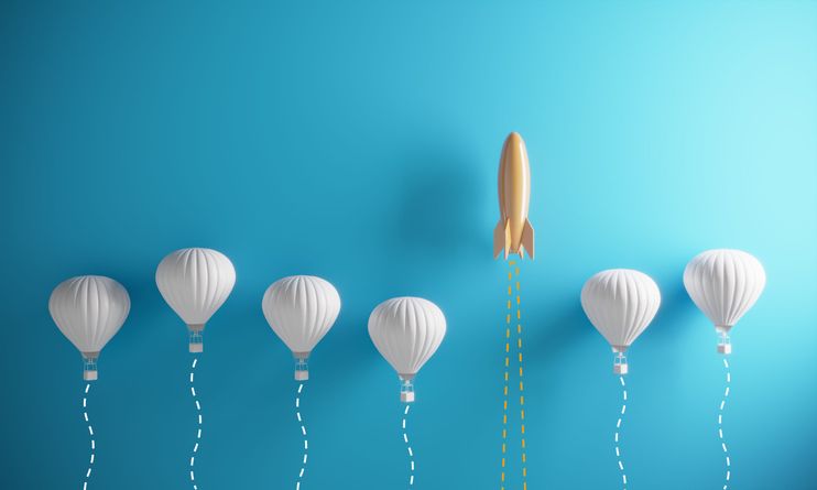 A rocket amongst balloons. Image showing the concept of standing out from the crowd.