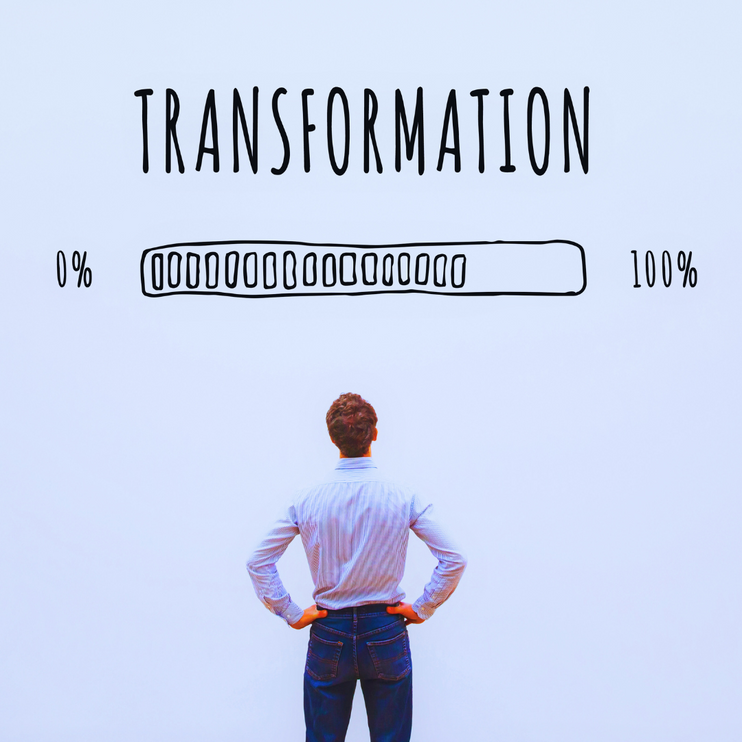 Image shows businessman looking at a wall with the word "transformation" above a loading bar going from zero to 100. The idea is that transformation is loading.